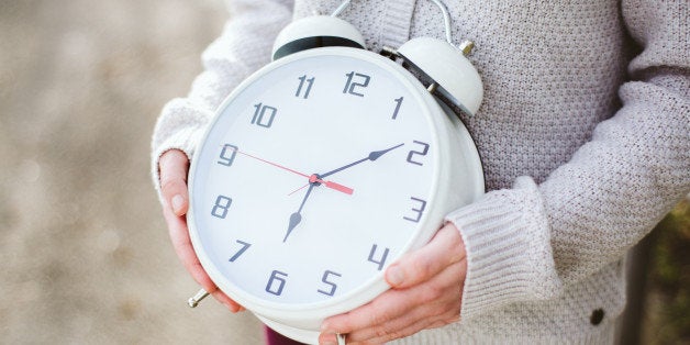 One woman holds a large clock.