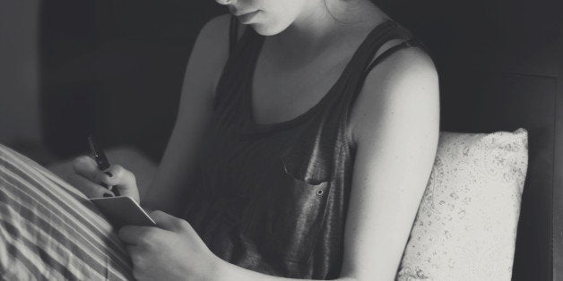 Young woman writing diary in bed