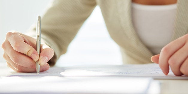 Hand of businesswoman writing with pen