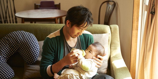 father giving milk to his baby