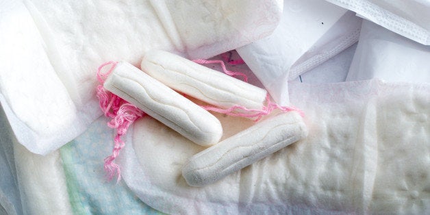 Sanitary pads for women with clean white tampons lying on top.