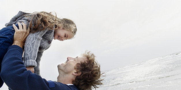 Father carrying daughter on the beach