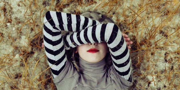 Young woman hidding her face with her arms