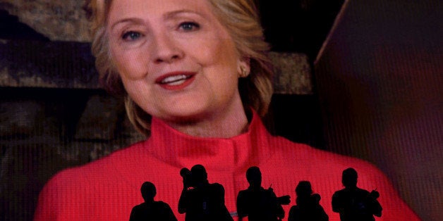 The silhouettes of photographers are seen as Hillary Clinton, 2016 Democratic presidential nominee, speaks on screen during t