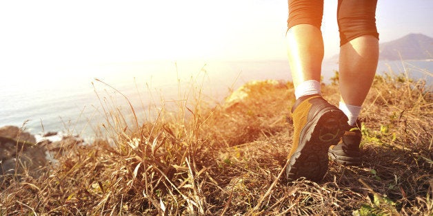 hiking feet walking on seaside mountain peak