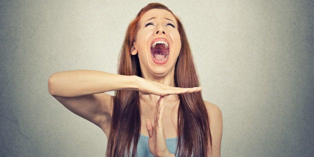 Young woman showing time out hand gesture, frustrated screaming to stop isolated on grey wall background. Too many things to do. Human emotions face expression reaction