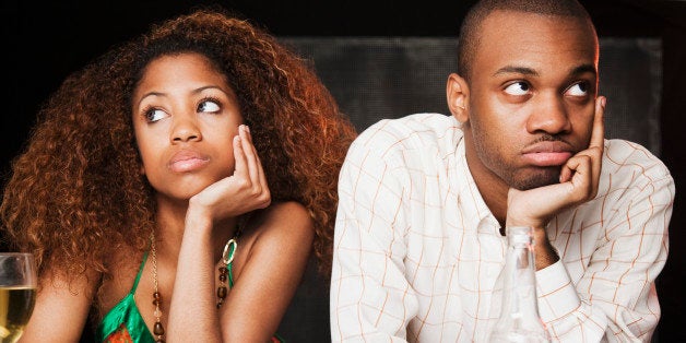 Couple sitting at bar and looking irritated