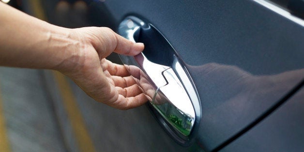 Hand on handle, man opening a car door on the street