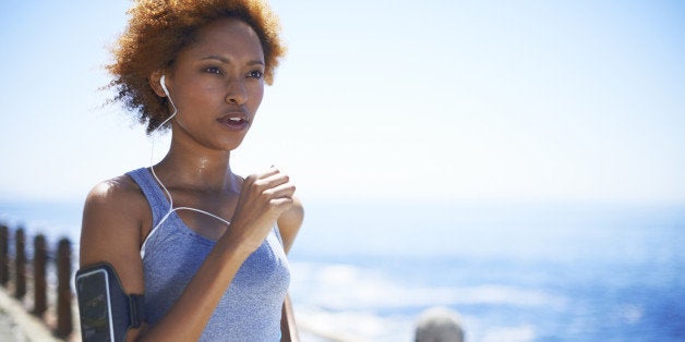 Determined young woman running on street by ocean