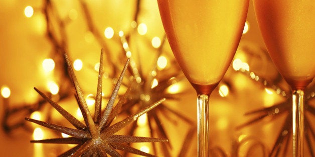 Romantic holiday drink, celebration of Christmas or new year eve, party with Champagne and festive gold ornament lights decor