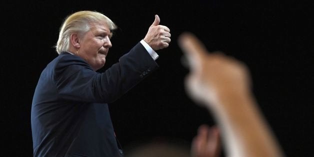 TOPSHOT - US Republican presidential nominee Donald Trump gestures at supporters during a campaign rally at the Orlando Melbo