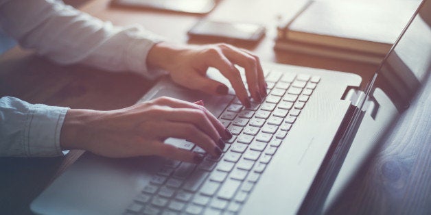 Working at home with laptop woman writing a blog. Female hands on the keyboard.