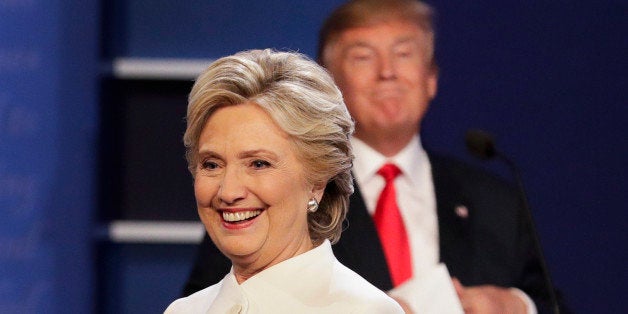 Democratic presidential nominee Hillary Clinton walks off stage as Republican presidential nominee Donald Trump puts his note