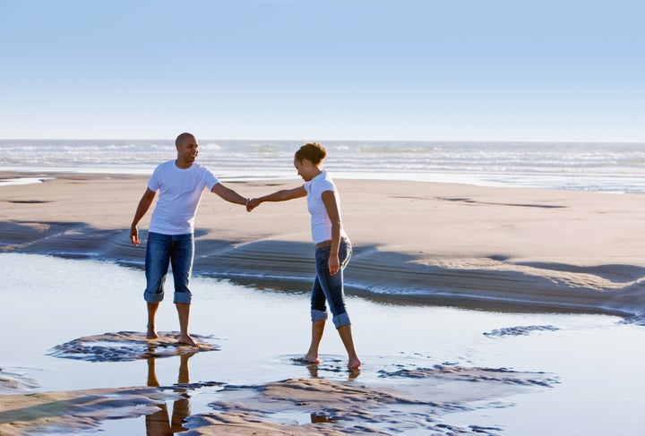 Couple walking on beach holding hands