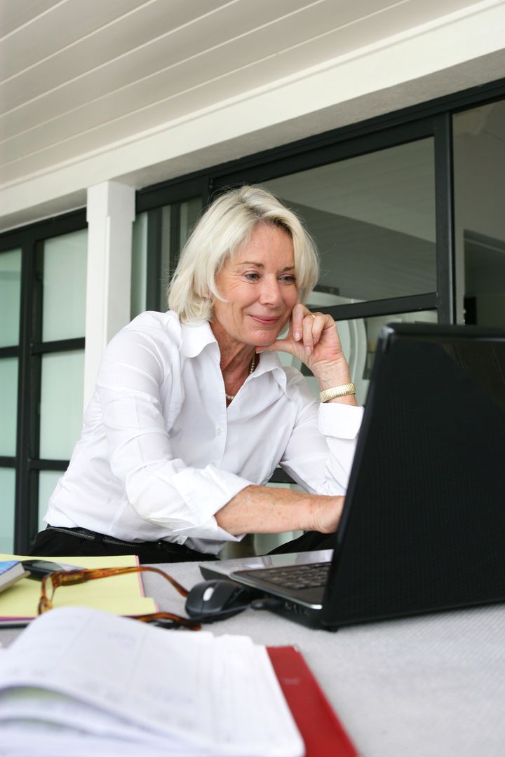 Portrait of a senior woman in front of a laptop computer