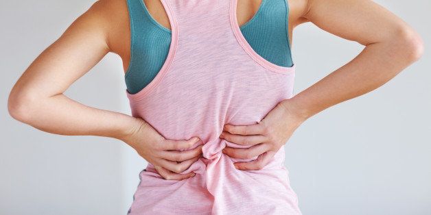 Closeup of young woman suffering from back pain