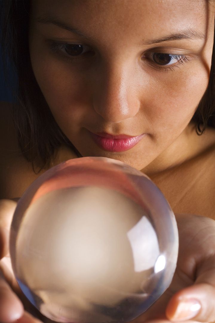 portrait of an exotic young woman staring into a crystal ball