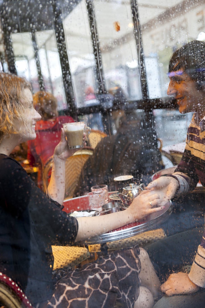 Happy couple in a Parisian cafe at rain