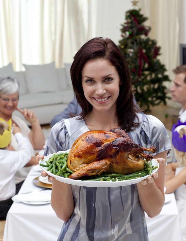 Woman showing to the camera Christmas turkey for dinner