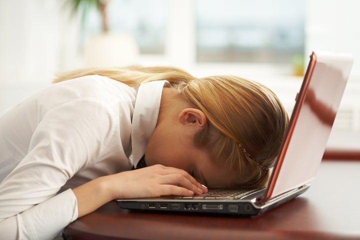 Image of very tired businesswoman or student with her face on keyboard of laptop