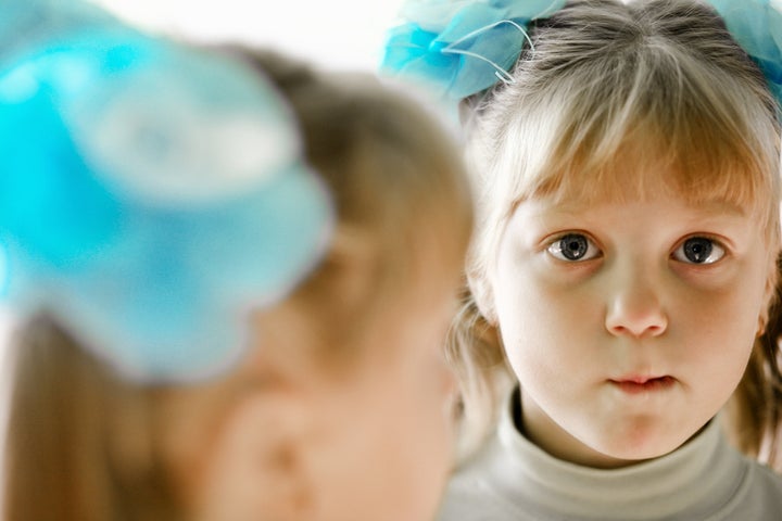 The little girl looks in the mirror