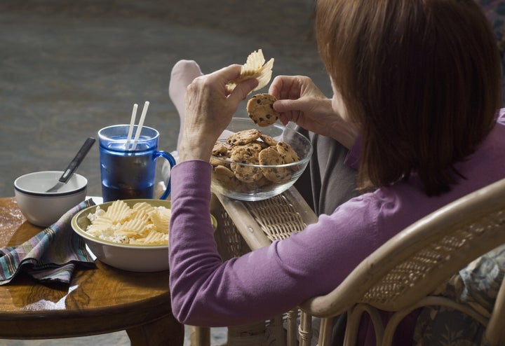 woman seated eating junk food