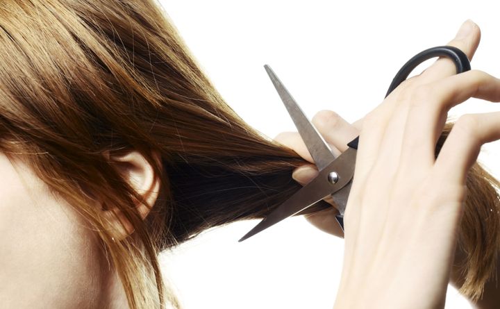 Woman going to cut her hair with scissors