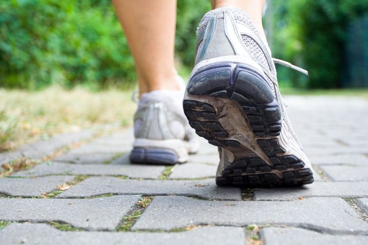 Woman walking on sidewalk, sport shoes closeup