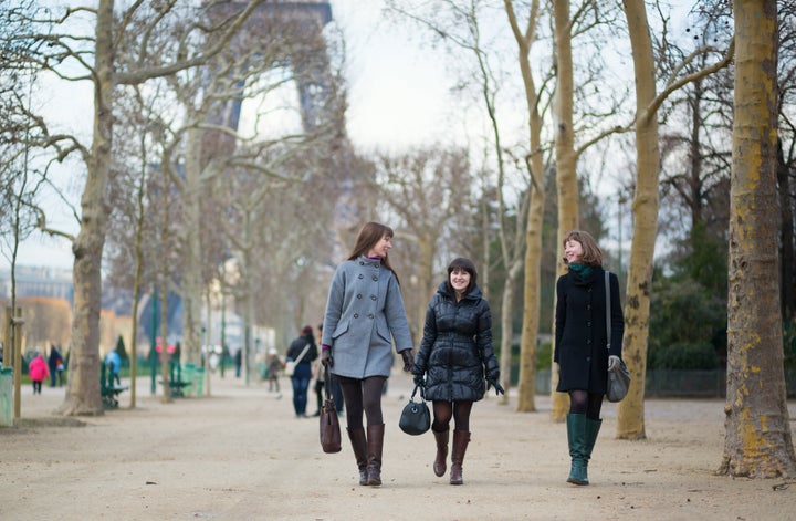 Three cheerful friends walking together in Paris