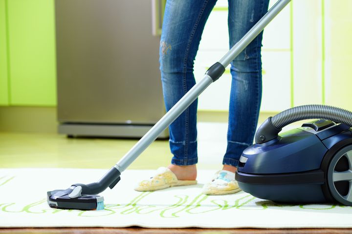 woman cleaning home with vacuum ...