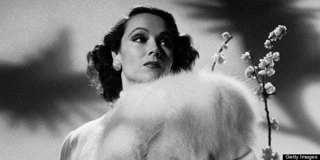 circa 1931: Mexican film star, Dolores Del Rio (1905 - 1983) stands on a polar bear skin rug in a fur-trimmed coat. (Photo by John Kobal Foundation/Getty Images)