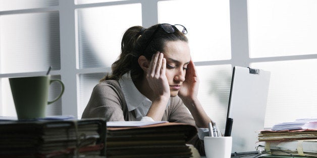 Exhausted businesswoman having a headache.