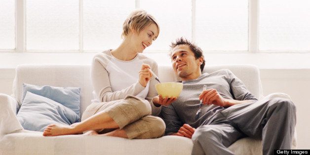 low angle view of a couple sitting on a couch and eating