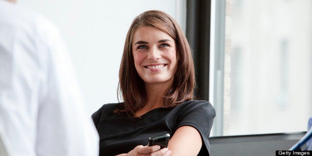 Smiling and Happy Business woman sitting at a corporate table with other Business men and conducting a group meeting to discu