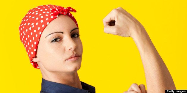 Strong Caucasian woman wearing blue shirt and red polka-dot bandana like 'We Can Do It' painting's Rosie the Riveter