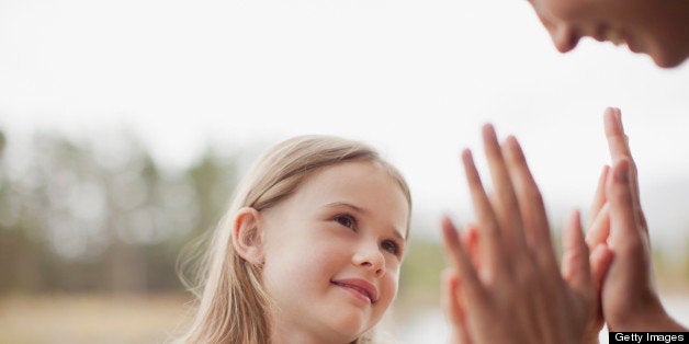 Close up of mother and daughter playing pat-a-cake