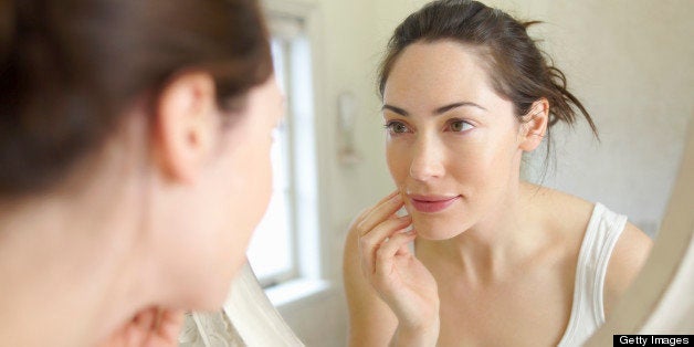 Woman looking at self in mirror.