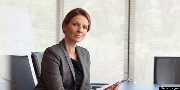 Portrait of smiling businesswoman with digital tablet in conference room