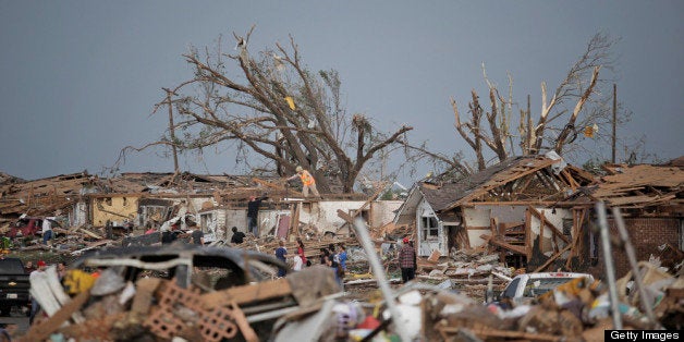 MOORE, OK - MAY 20: People assess the damage after a powerful tornado ripped through the area on May 20, 2013 in Moore, Oklahoma. The tornado, reported to be at least EF4 strength and two miles wide, touched down in the Oklahoma City area on Monday killing at least 51 people. (Photo by Brett Deering/Getty Images)