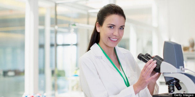 Portrait of confident scientist using microscope in laboratory