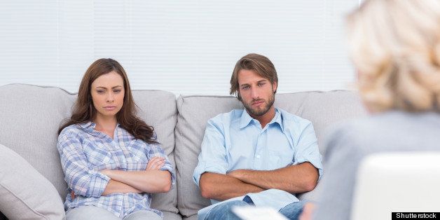 upset couple sit on a sofa with ...