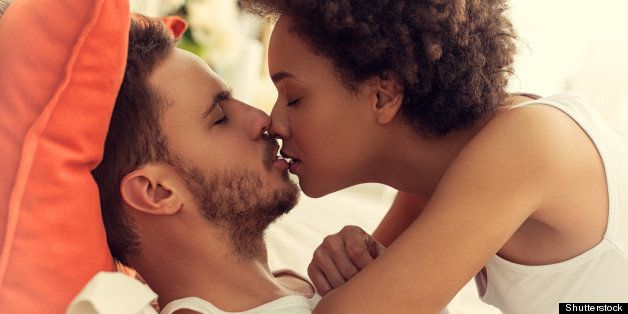 mixed race couple kissing in...