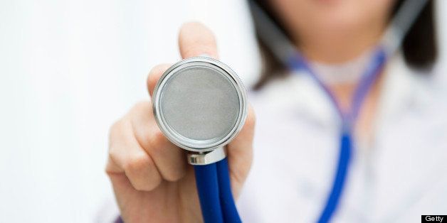 A woman doctor holds a stethoscope up to the camera. shallow Depth Of Field