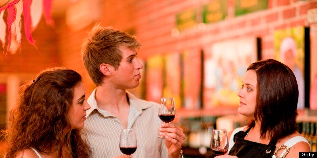 Server and customers tasting wine