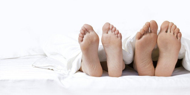 couple's feet on the bed