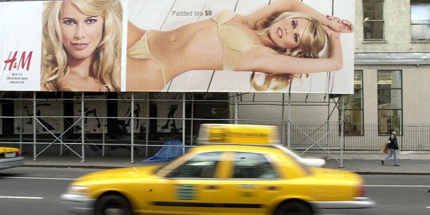 383191 03: A taxicab drives by a billboard featuring model Claudia Schiffer advertising the winter underware collection of clothing retailer H&M December 12, 2000 in New York City. (Photo by Chris Hondros/Newsmakers)