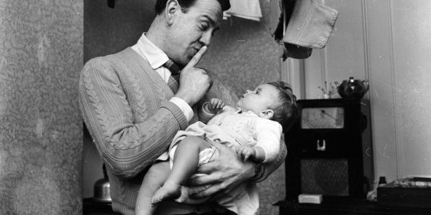February 1957: Former press operator John Millar adds babysitting to his resume. He is a member of an odd-job pool formed by the many men and women who lost their jobs at the Dagenham motor works through redundancy. (Photo by Lee Tracey/BIPs/Getty Images)