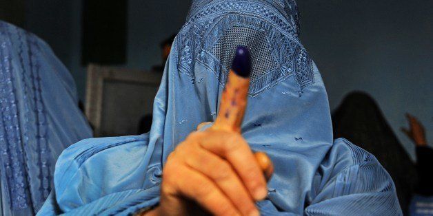 An Afghan woman shows her inked finger after voting at a polling station in the northwestern city of Herat on April 5, 2014. Afghan voters went to the polls to choose a successor to President Hamid Karzai, braving Taliban threats in a landmark election held as US-led forces wind down their long intervention in the country. AFP PHOTO/AREF KARIMI (Photo credit should read Aref Karimi/AFP/Getty Images)