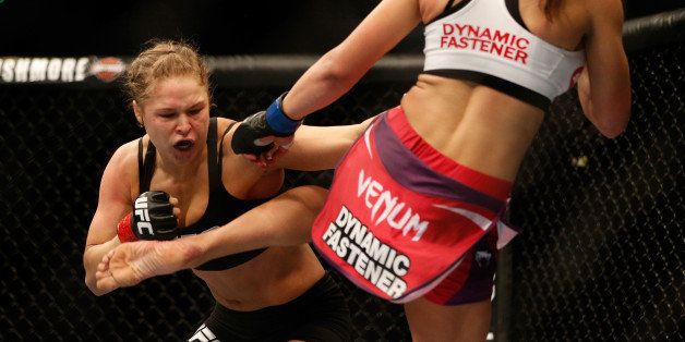 LAS VEGAS, NV - DECEMBER 28: (R-L) Miesha Tate kicks Ronda Rousey in their UFC women's bantamweight championship bout during the UFC 168 event at the MGM Grand Garden Arena on December 28, 2013 in Las Vegas, Nevada. (Photo by Josh Hedges/Zuffa LLC/Zuffa LLC via Getty Images) 
