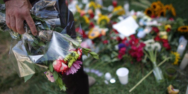 ISLA VISTA , CA - MAY 25: A man places flowers on the lawn of the Alpha Phi sorority house May 25, 2014 in Isla Vista, California. According to reports, 22 year old Elliot Rodger, son of assistant director of the Hunger Games, Peter Rodger, began his mass killing near the University of California in Santa Babara by stabbing three people to death in an apartment. He then went on to shooting people while driving his BMW and ran down at least one person until crashing with a self-inflicted gunshot wound to the head. Officers found three legally-purchased guns registered to him inside the vehicle. Prior to the murders, Rodger posted YouTube videos declaring his intention to annihilate the girls who rejected him sexually and others in retaliation for his remaining a virgin at age 22. Seven people died, including Rodger, and seven others wounded, according to authorities. (Photo by David McNew/Getty Images)